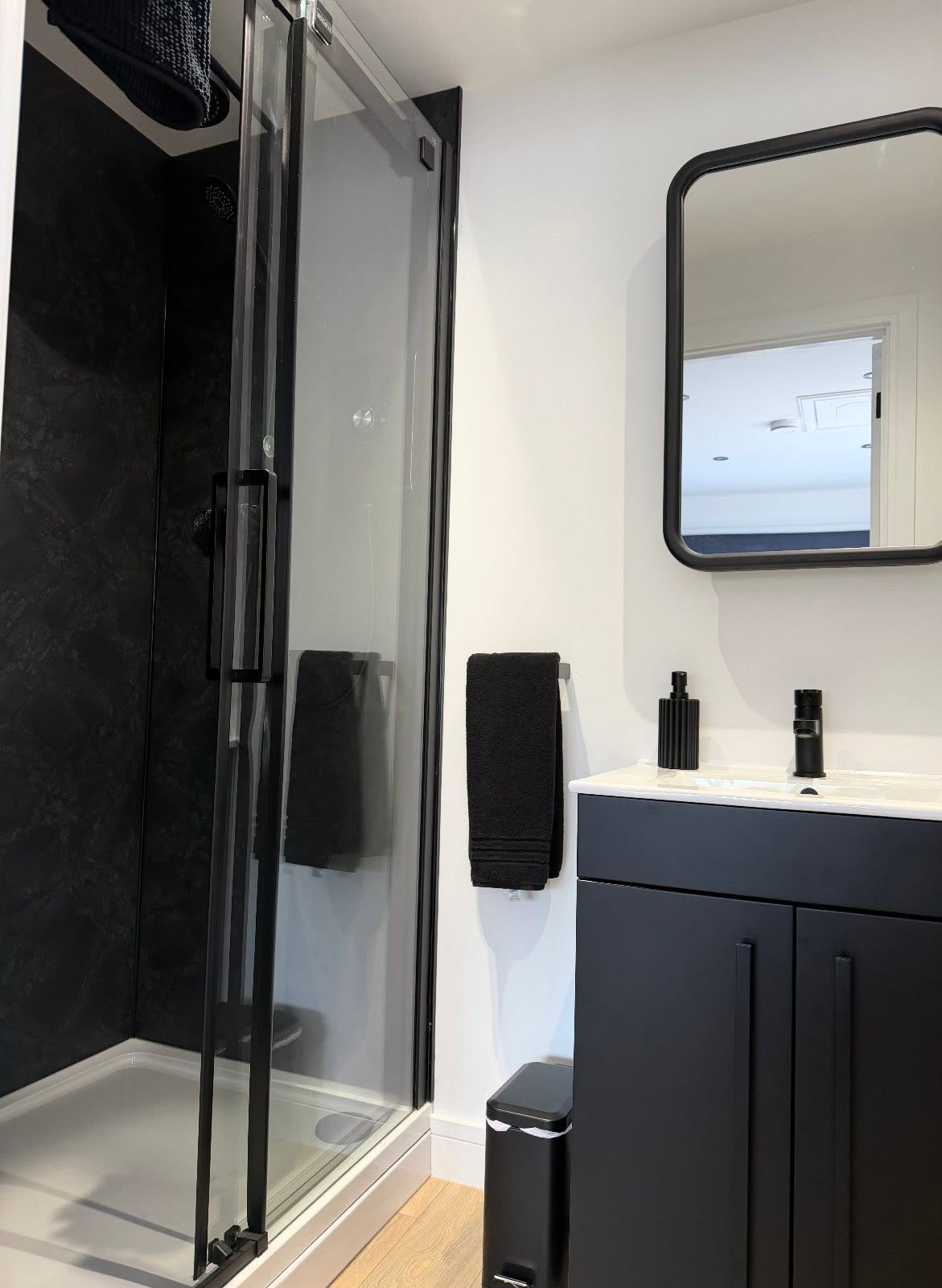 Finished bathroom refurbishment with black fittings and walk-in shower