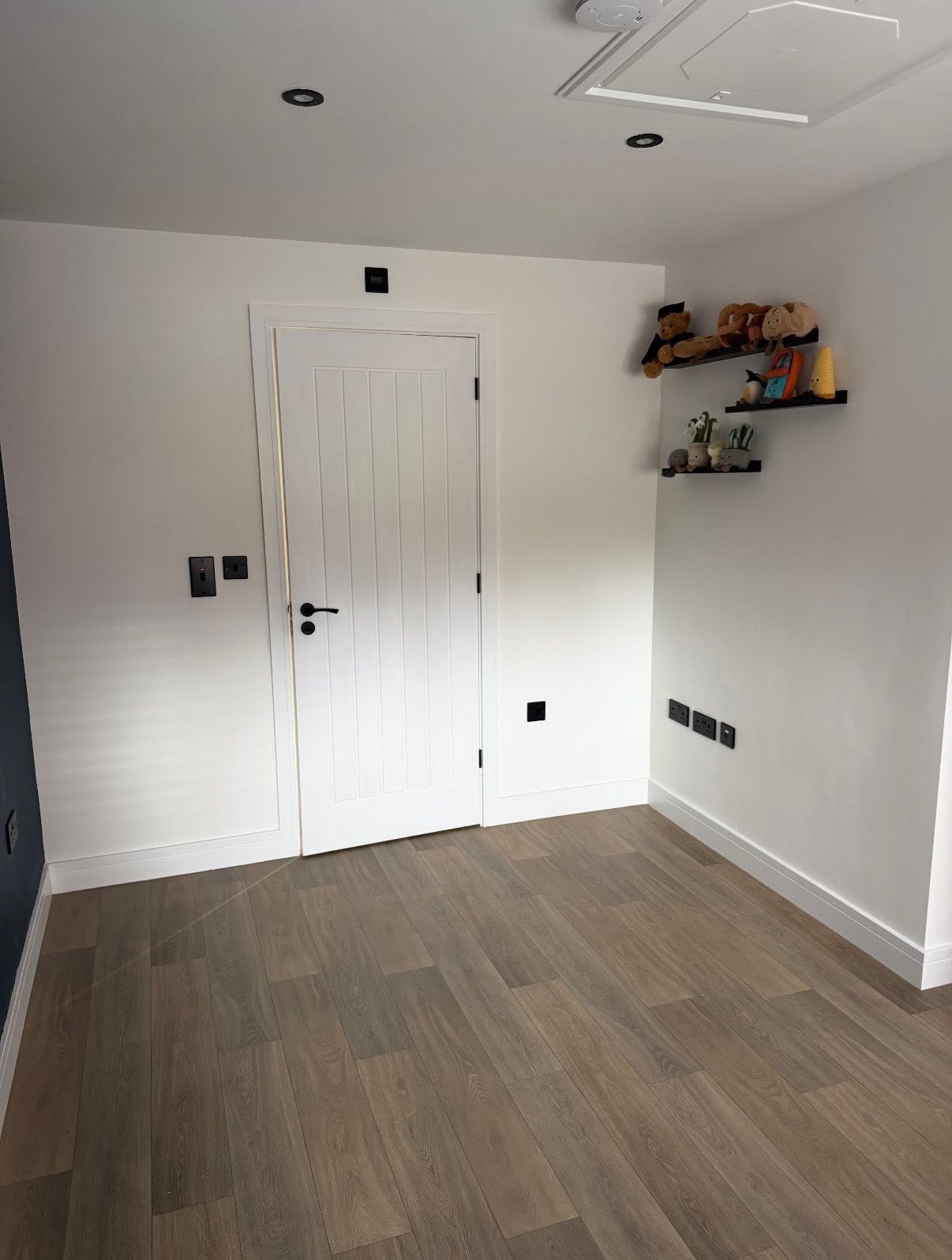 Finished bedroom with new flooring and white door
