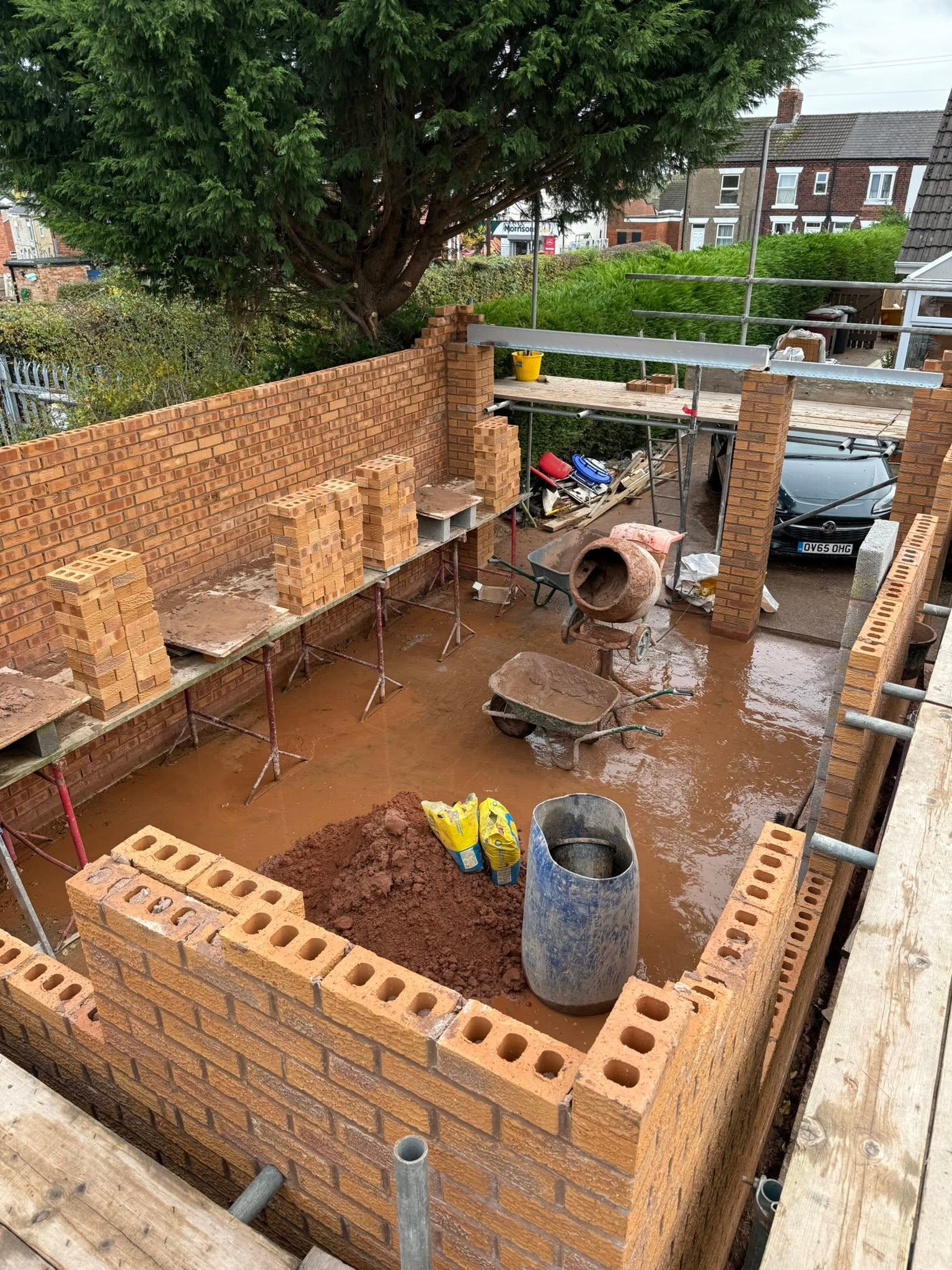 Brick extension under construction with blockwork and scaffolding