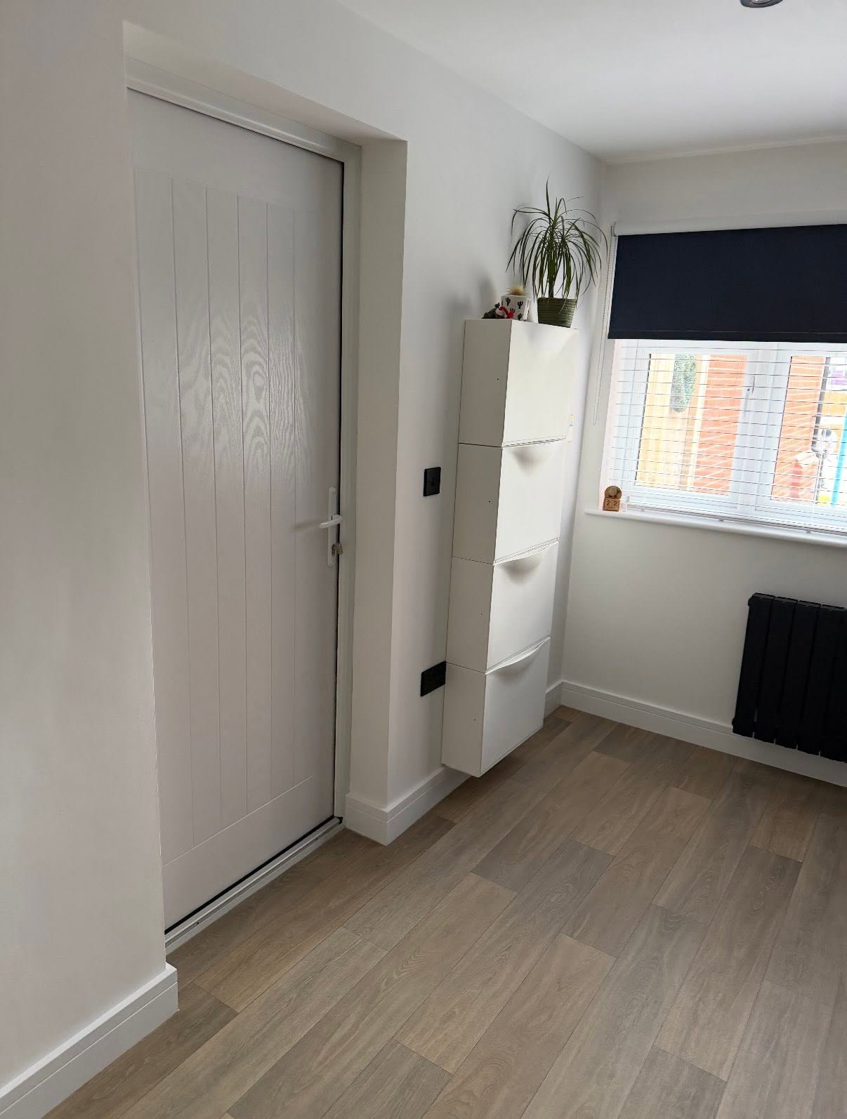 Finished hallway with new flooring and white panelled door