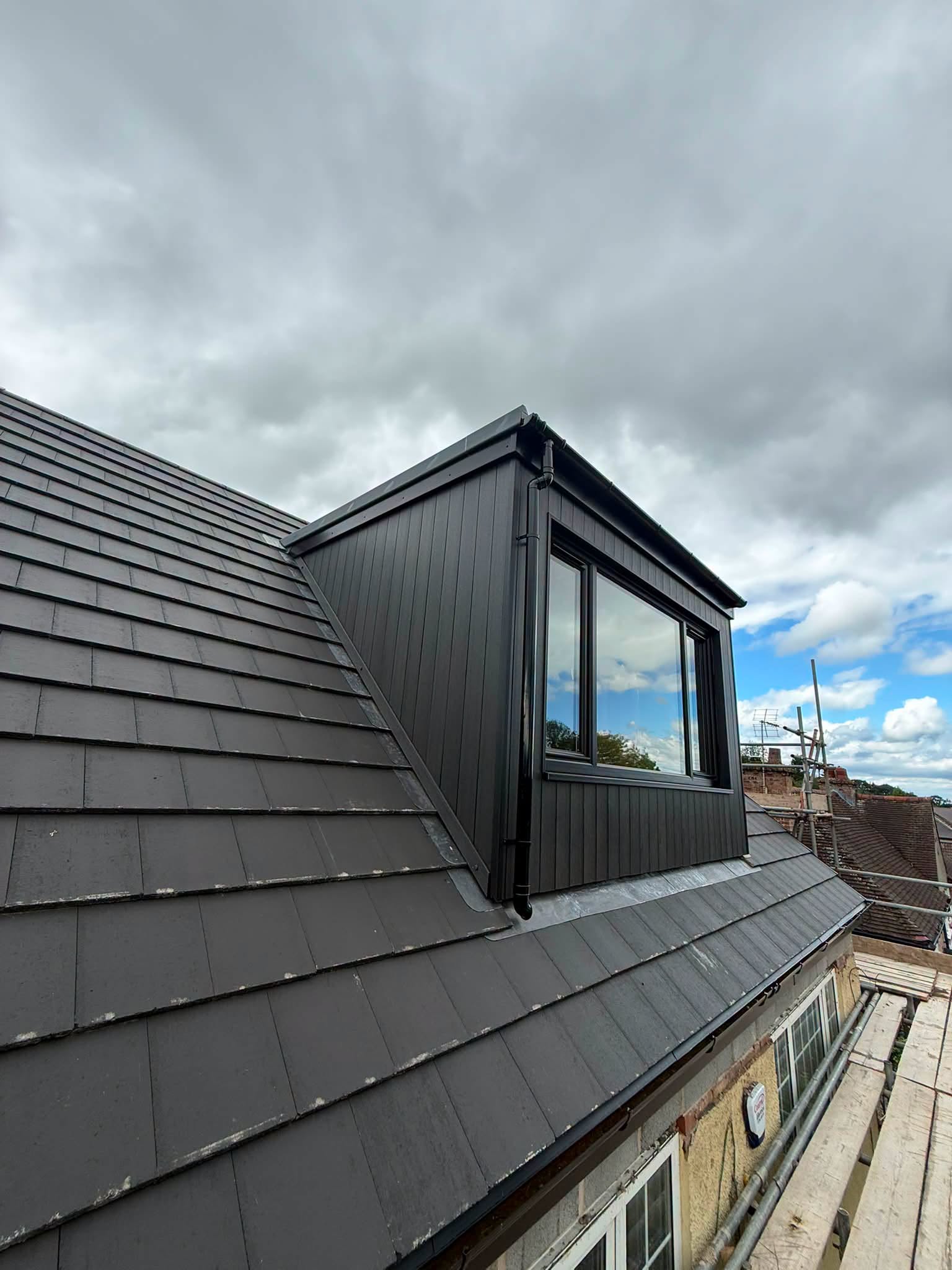 Finished loft conversion dormer with black cladding and fitted window, Wingerworth