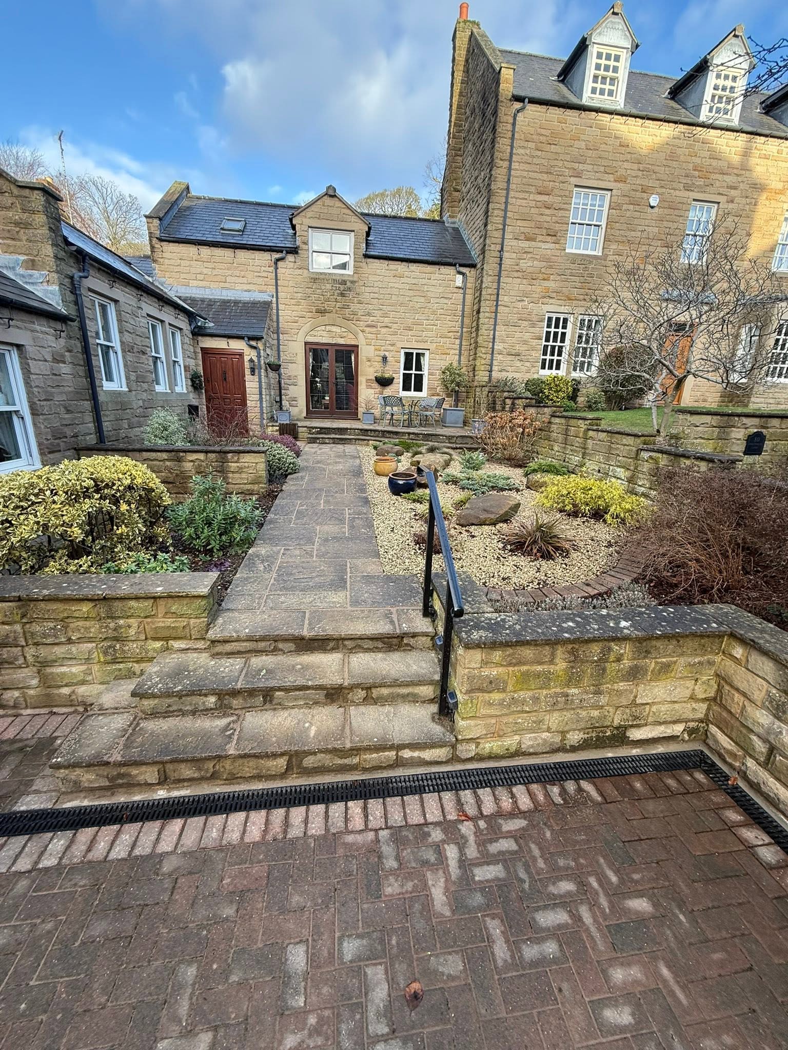Renovated period stone home exterior with landscaped garden